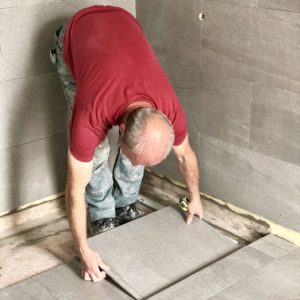 carreleur entrain de poser du carrelage pour une rénovation